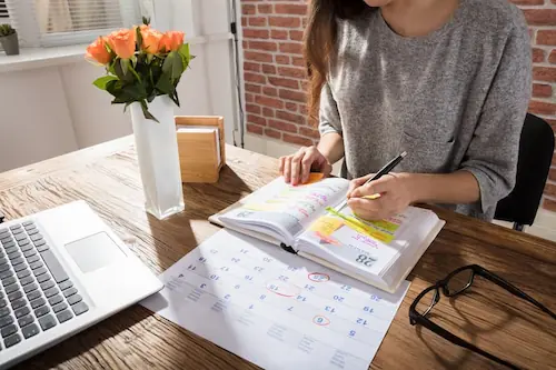 busy woman working at a table, working a packed calendar